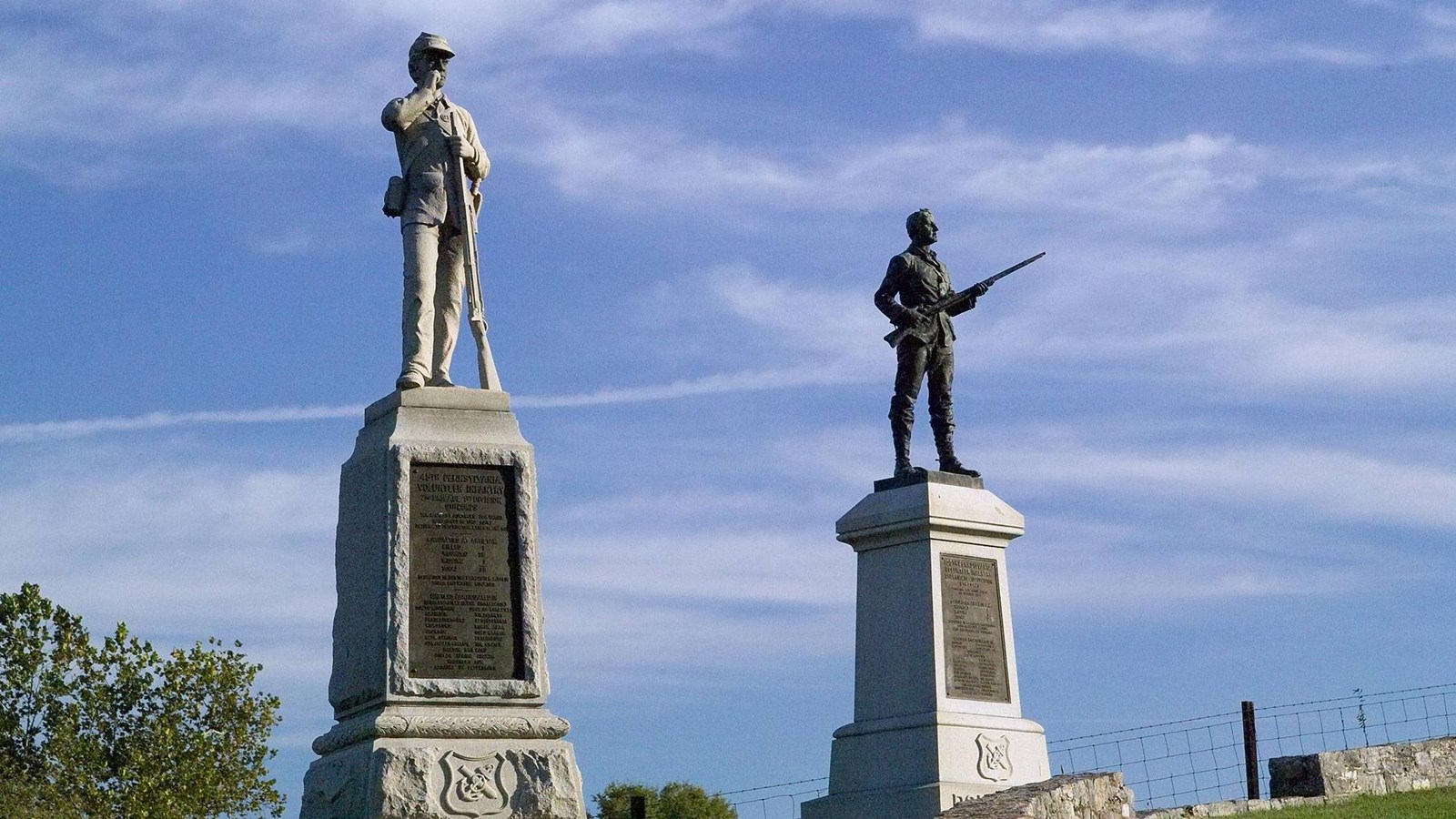 The 45th and 100th Pennsylvania Infantry monuments, both are stone columns with soldiers at the top.