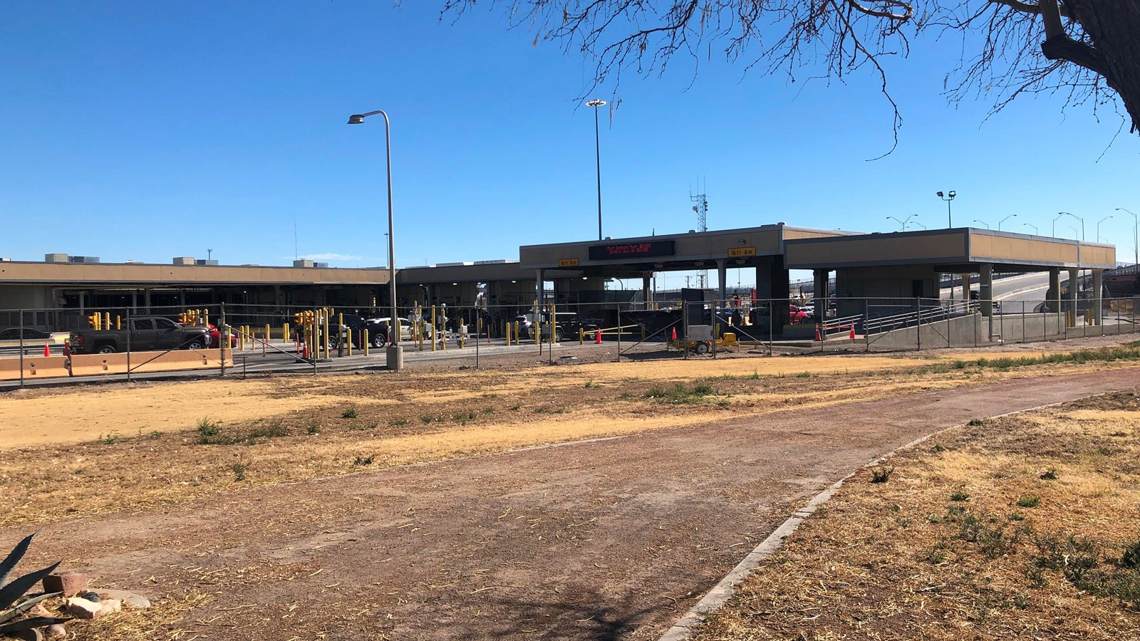 A roofed structure spans several lanes of traffic and connects to a building.
