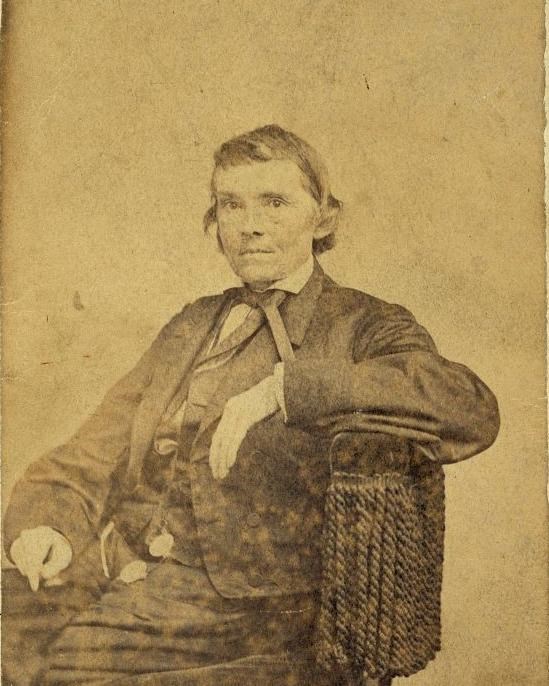 Man wearing three-piece suit sitting in a chair