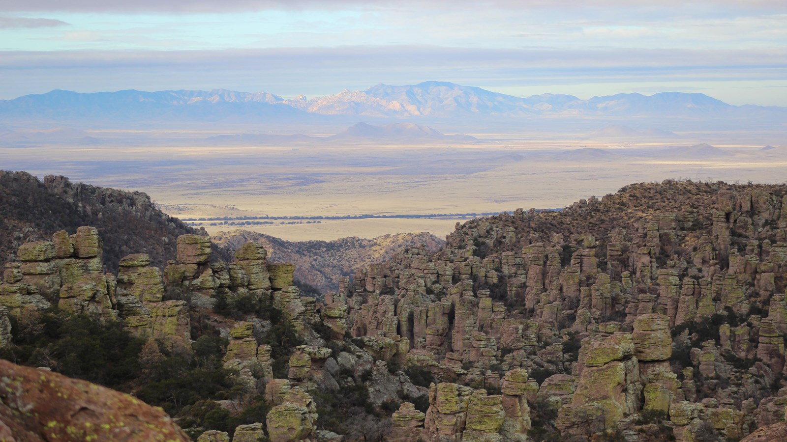 Rock formations with a valley and distant mountains in the background