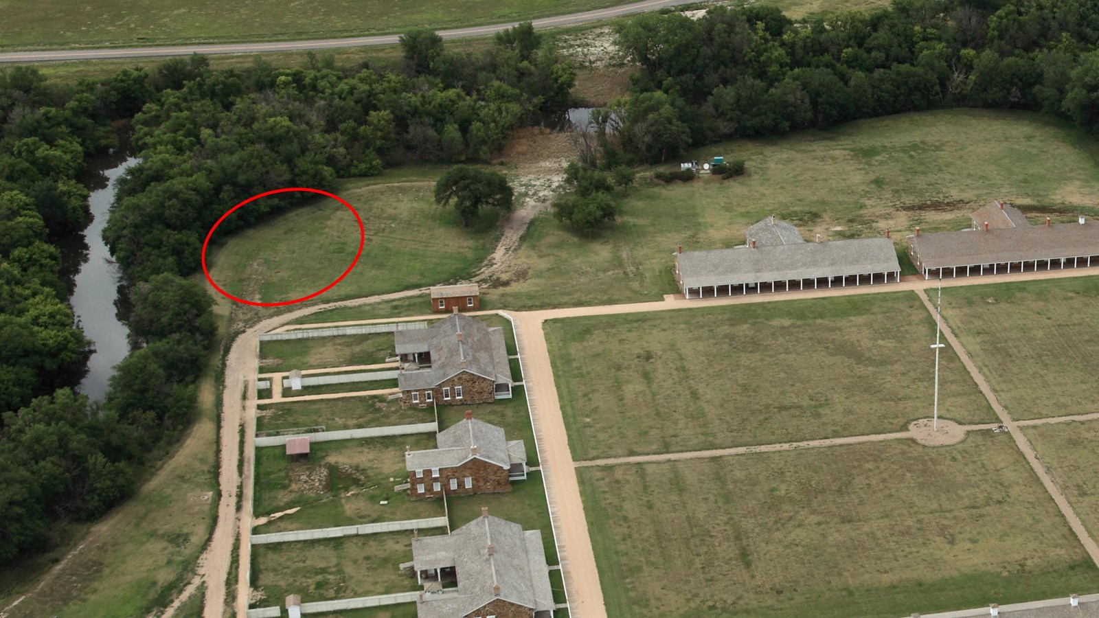 Aerial view of Pawnee River bank behind Officers\' Row with dugout location circled in red.