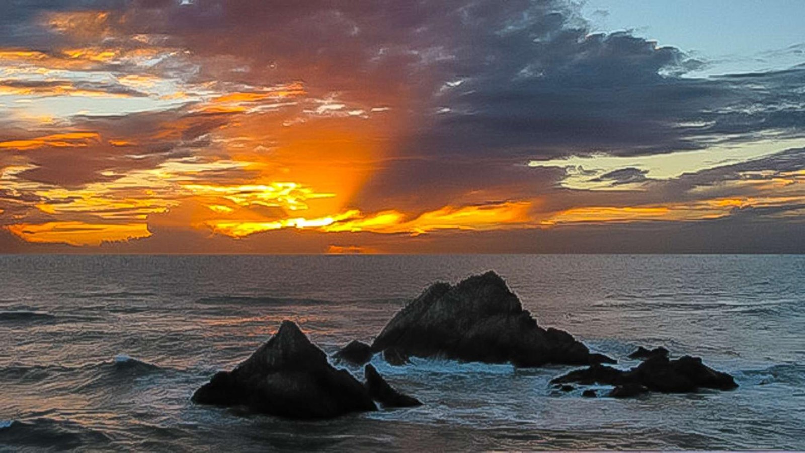  A dramatic view of the sun setting behind Seal Rocks as the clouds light up above the Pacific Ocean