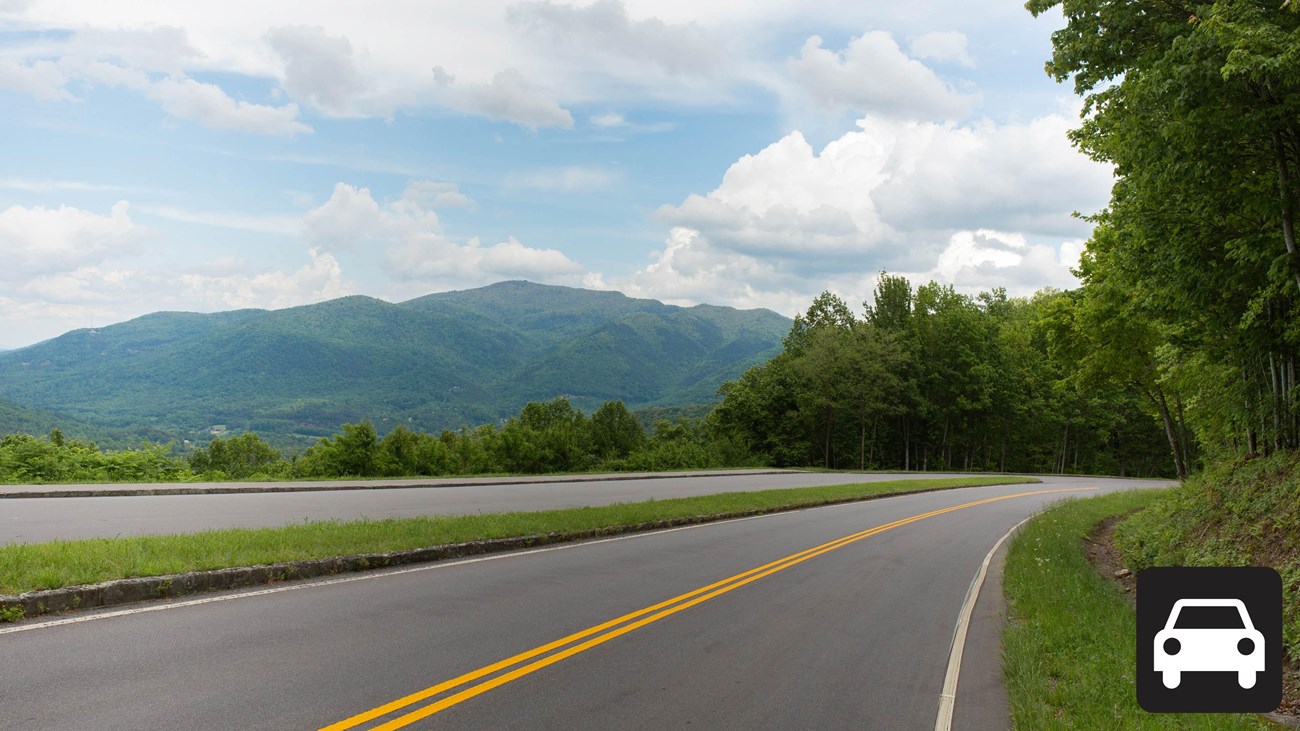 A road with a scenic mountain view and large pull-off.