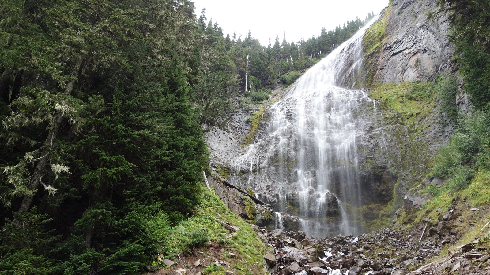 Veil-like waterfall cascading over lava cliff