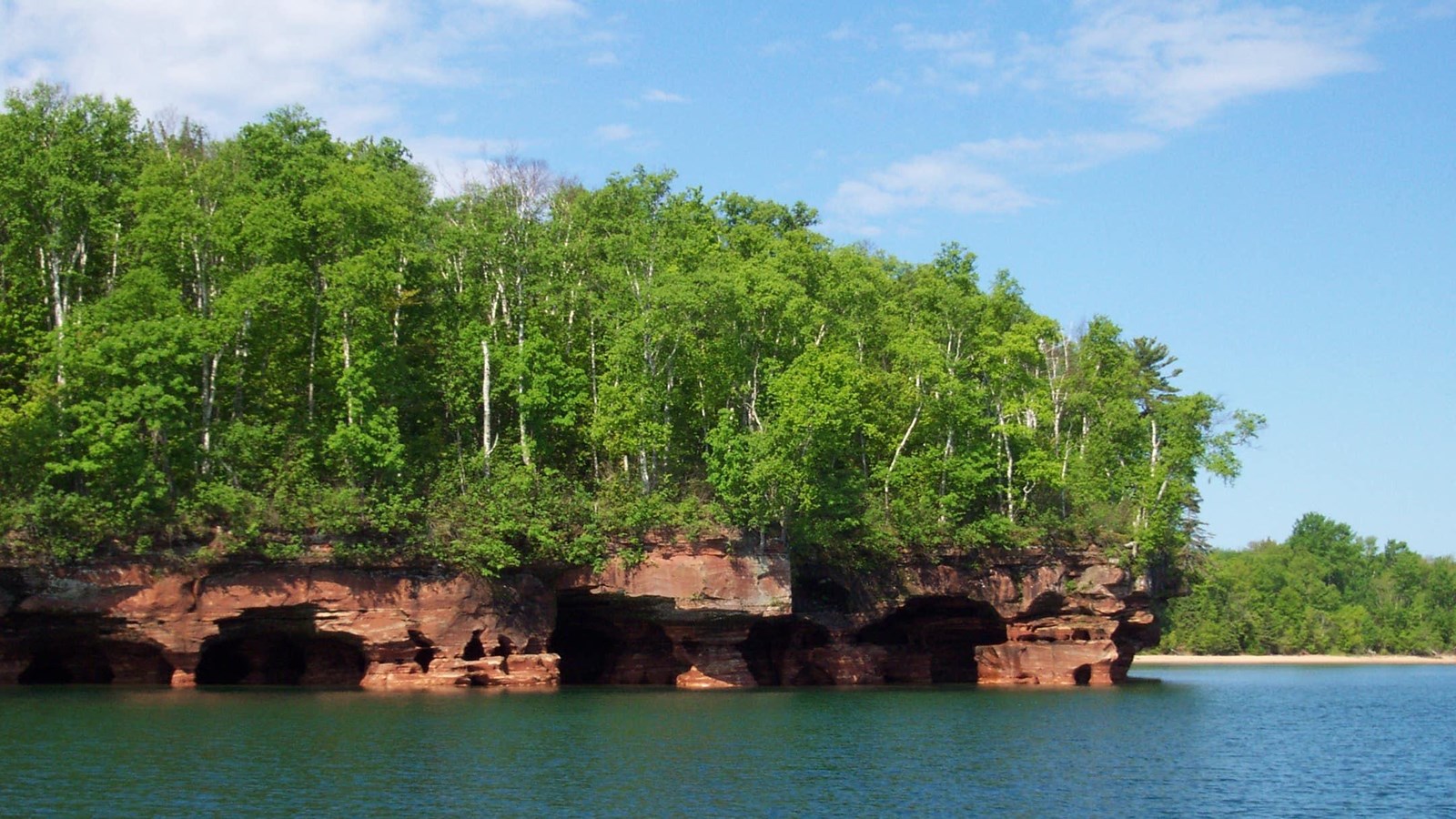Forested sandstone cliffs on the Lake Superior shore.