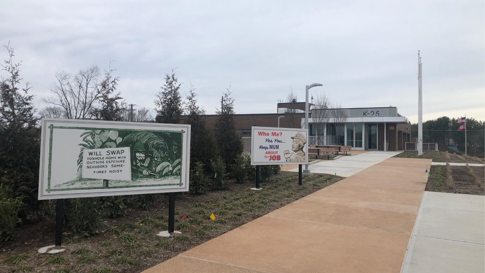 Walkway with historic signs leads to one-story modern building