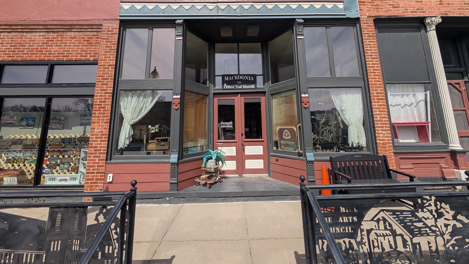 The front steps and entrance door of a historic red and gray stone building. 