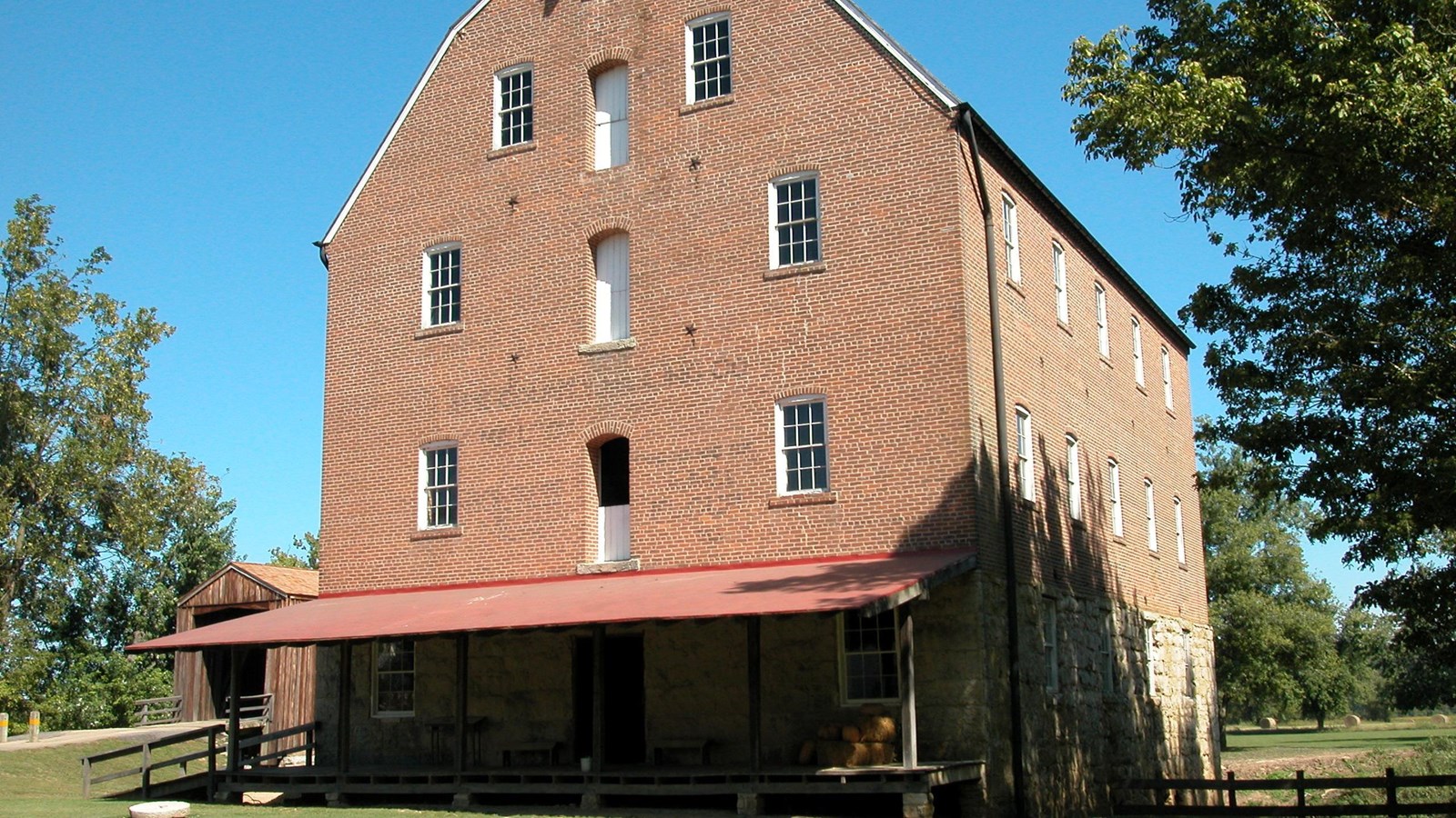A large, red-brick, barn-type building with a pitched roof.