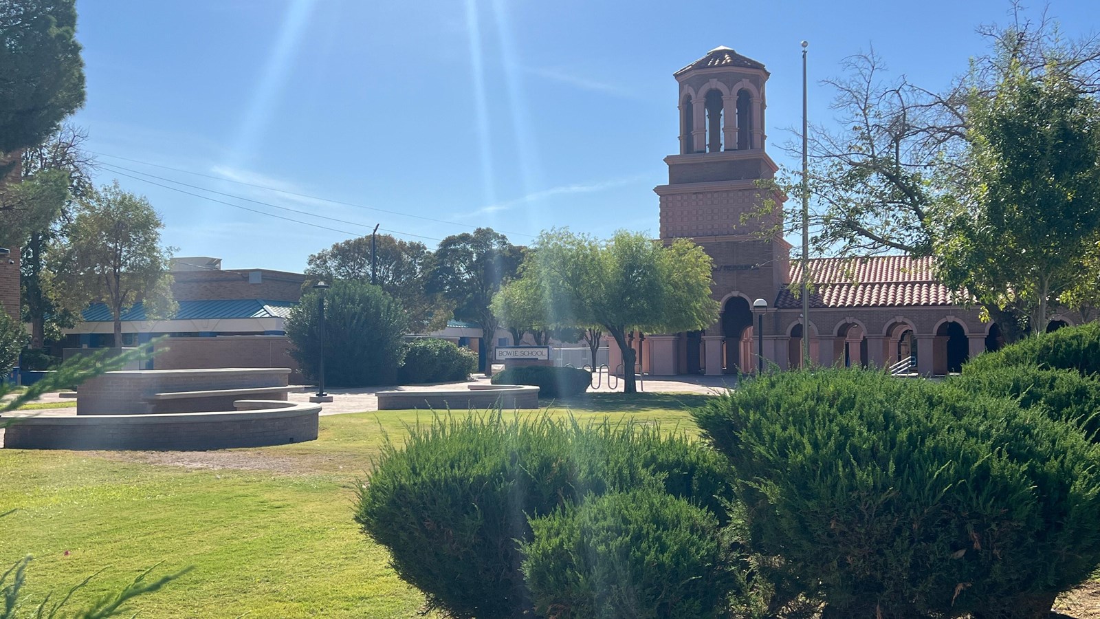Photo of historic school with a green courtyard with trees. 