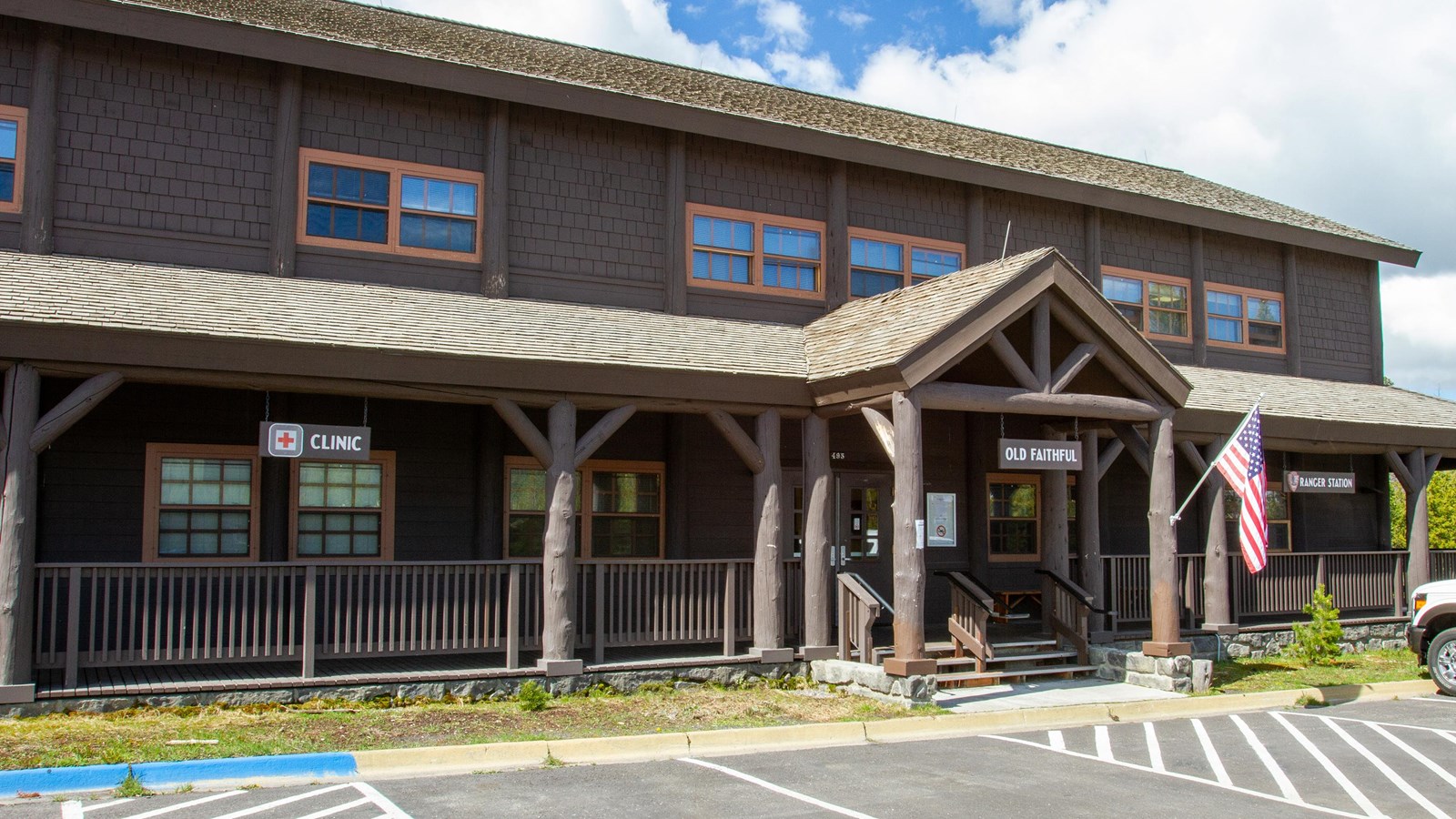 rustic log building with a red cross on the front