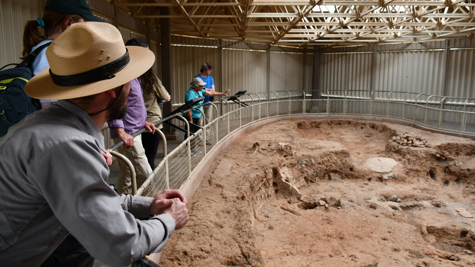 Pithouse dug into the earth featuring a fire pit, storage cysts, and foundation holes.