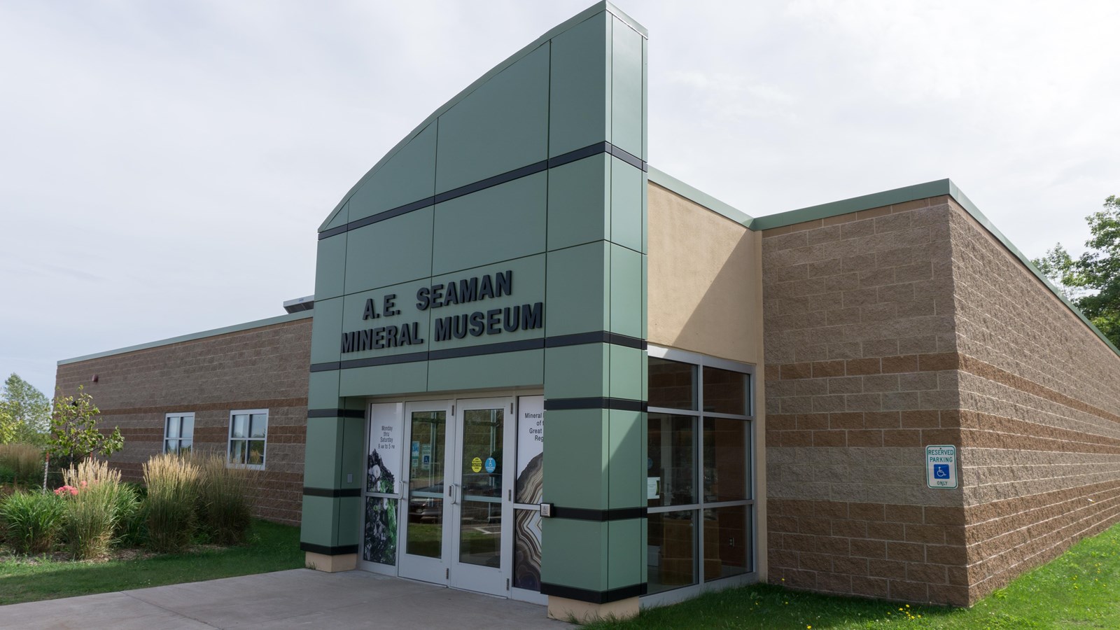 Red brick building with green metal front. A sign above the door reads A.E. Seaman Mineral Museum