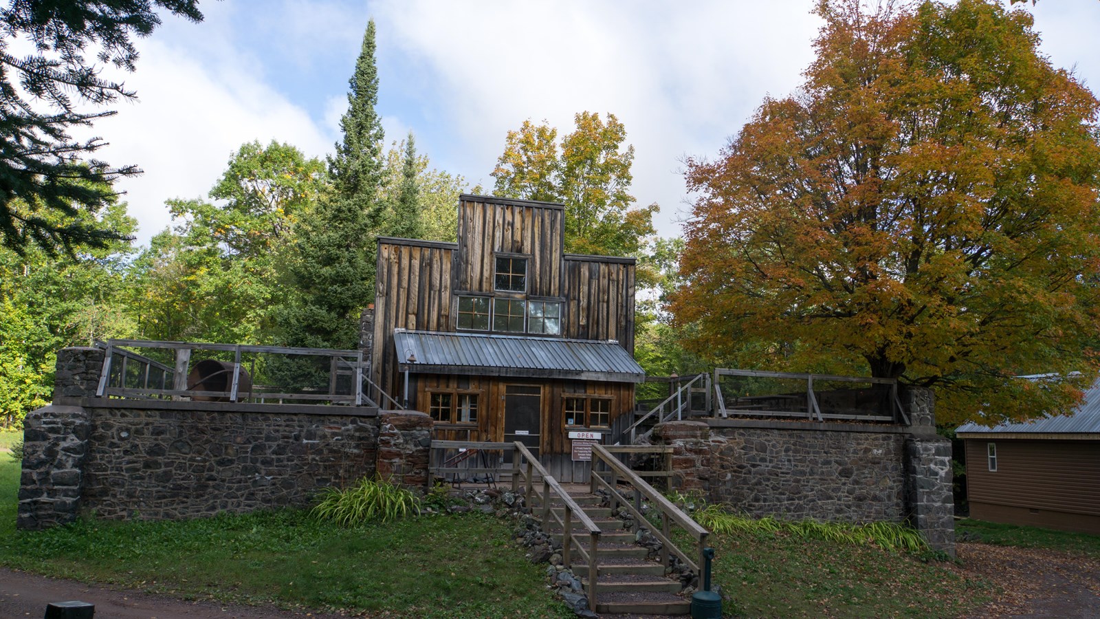 wooden building with a false-front and prominent mortared poor-rock wall and stairs to the entrance