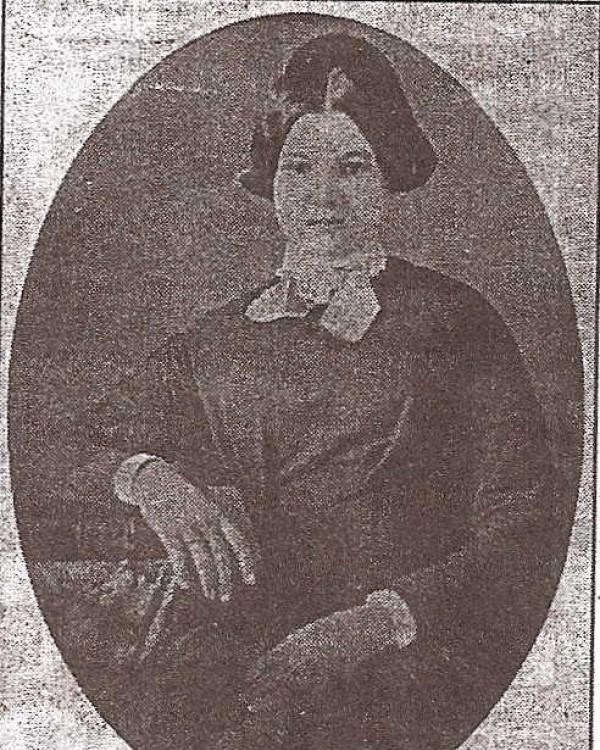 Young woman with dark hair and wearing a dark dress, taken from a newspaper article