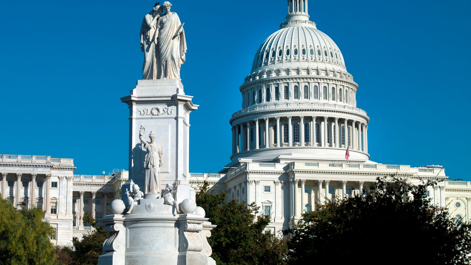 White marble Peace Monument in foreground with Capitol dome in background