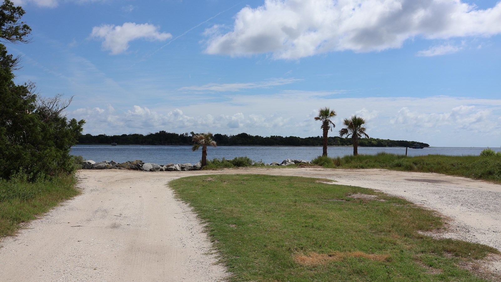 A dirt road makes a loop next to a river. 