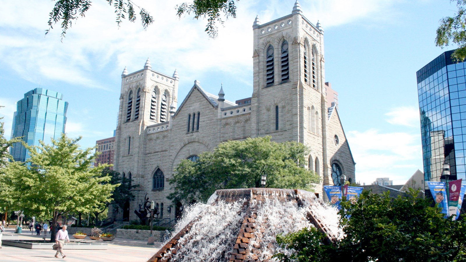 Gothic and Romanesque style limestone church split into three sections: two towers and central gable