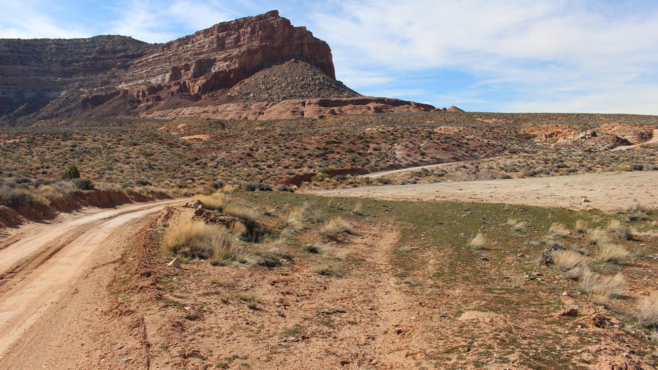A dirt road with large sandstone boulder