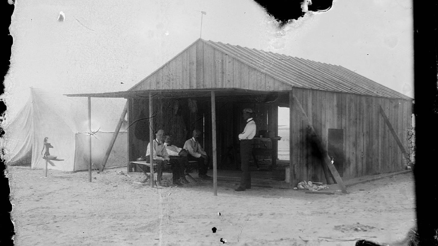 The Wright Brothers camp building with Octave Chanute, Orville, Edward Huffaker (seated) and Wilbur.