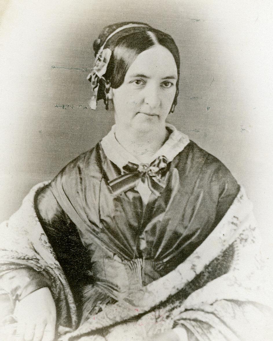 A woman in a silk dress siting wrapped in a shawl.