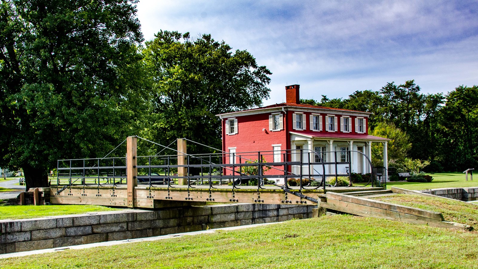 A red building stands next to a small canal.