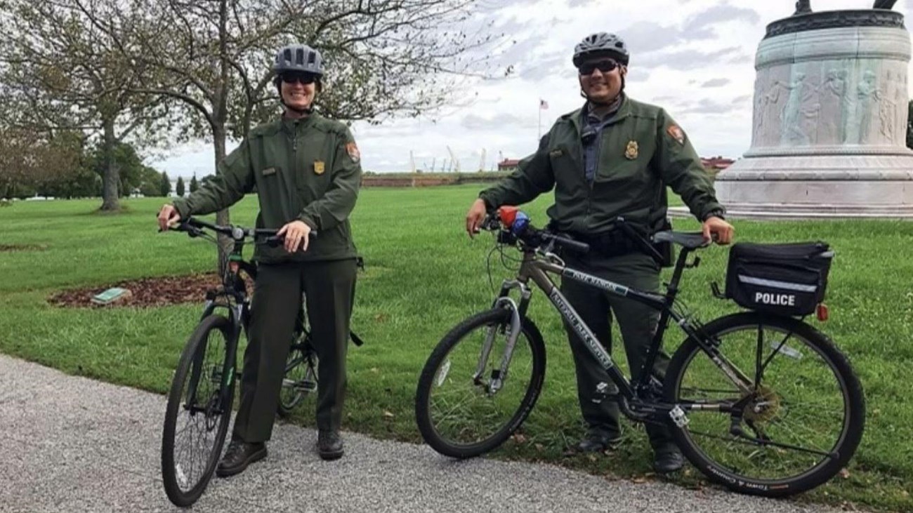 Two rangers on bikes with helmets on.