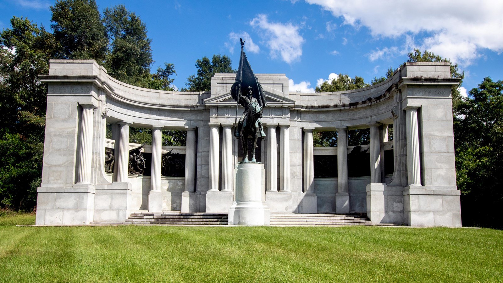 A frontal view of the granite monument with a bronze equestrian statue of a soldier holding a flag.