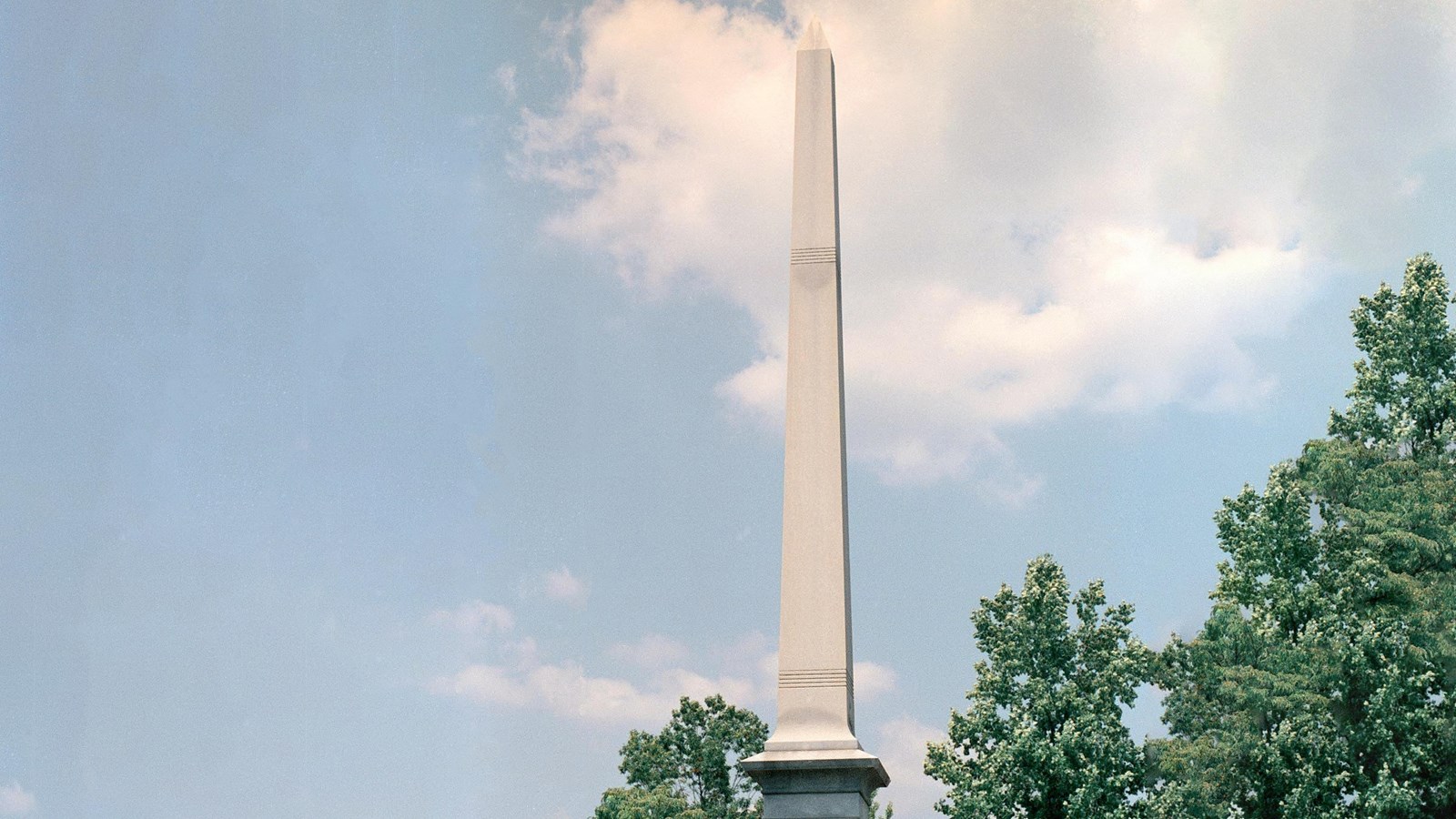 A tall stone column with inscriptions near the base. 