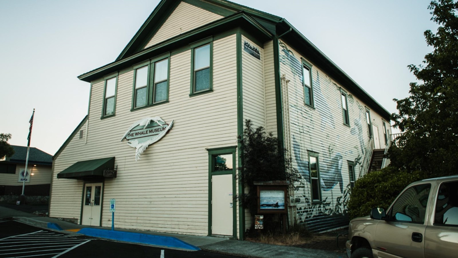 white clapboard three story maritime style building,  Text on the building reads 