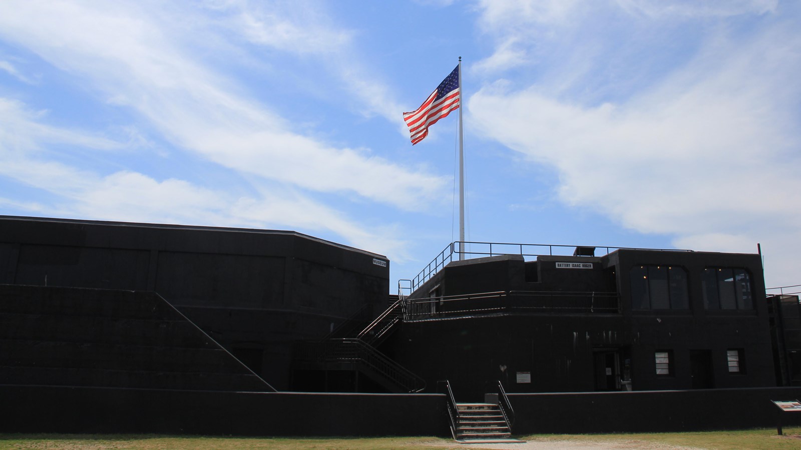 Black concrete structure with staircases running up it with US flag flying above it