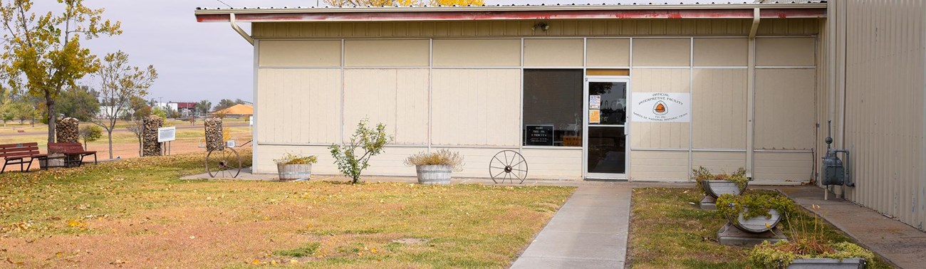 A walkway leads to a door in a one-story building.