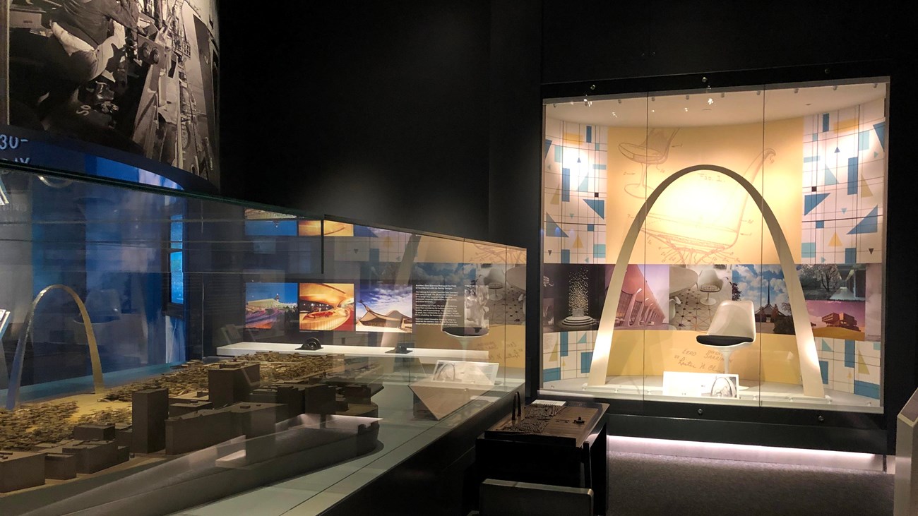 two glass cases, one holding a model of the Arch grounds and one a large model of the Arch structure