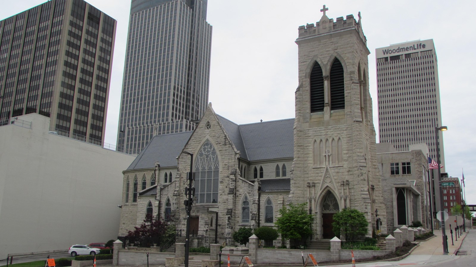 Gothic Revival church on corner lot in commercial downtown. Gables on two facades, separate by tower