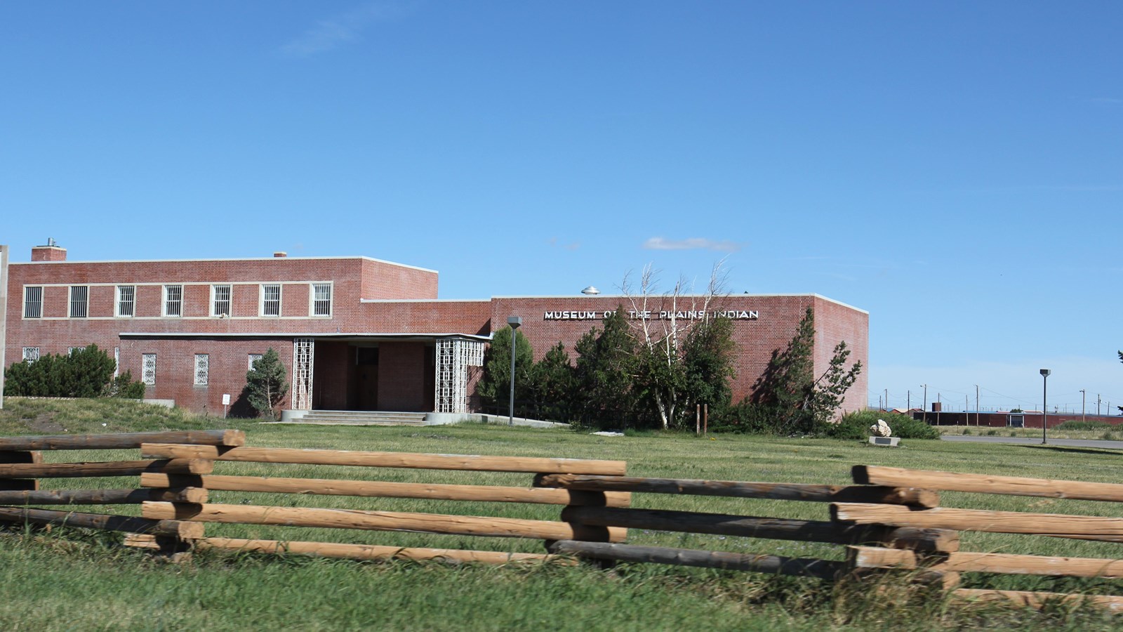 A large two-story red brick building with wide cement steps leading to a covered porch