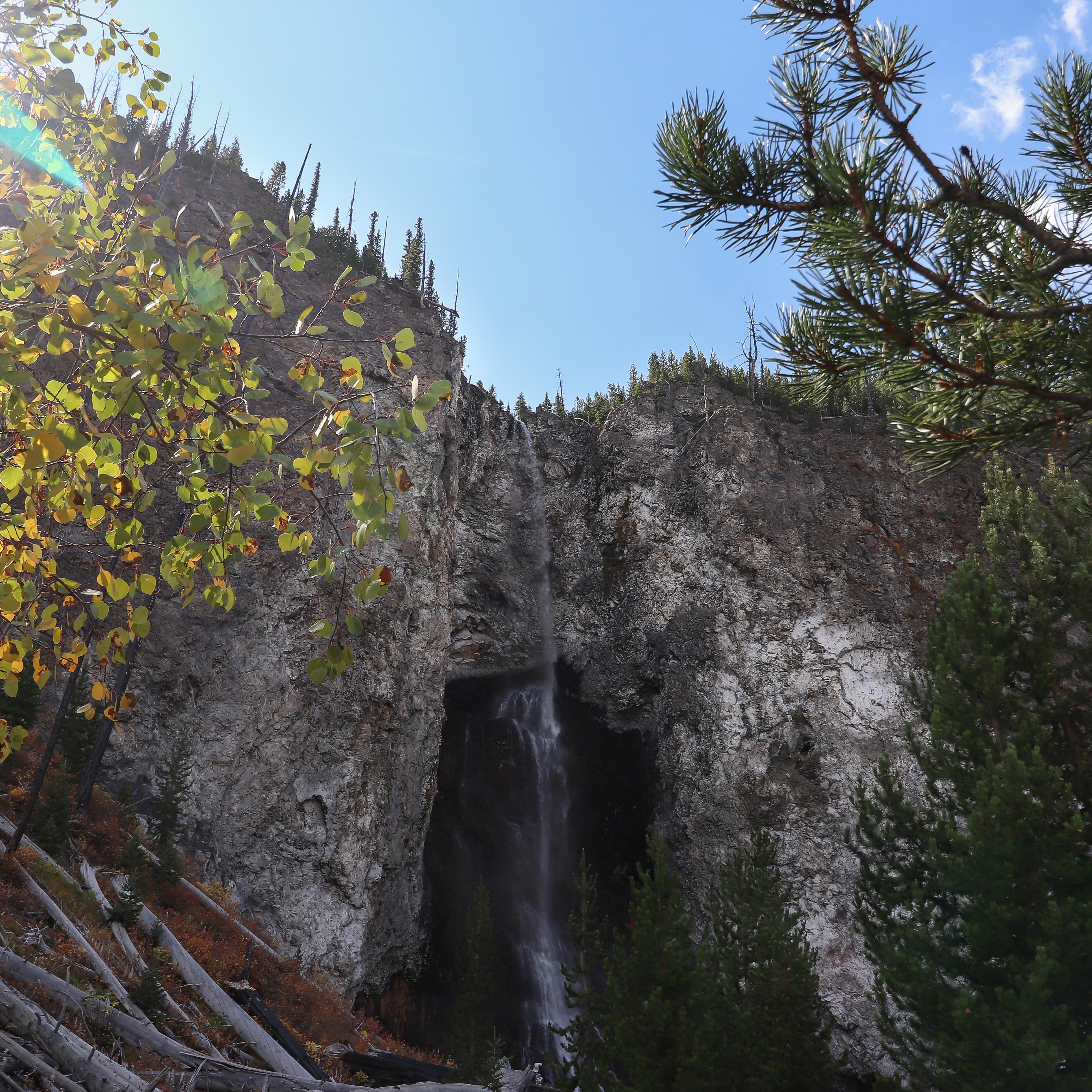 A thin waterfall cascades down a rocky cliff.