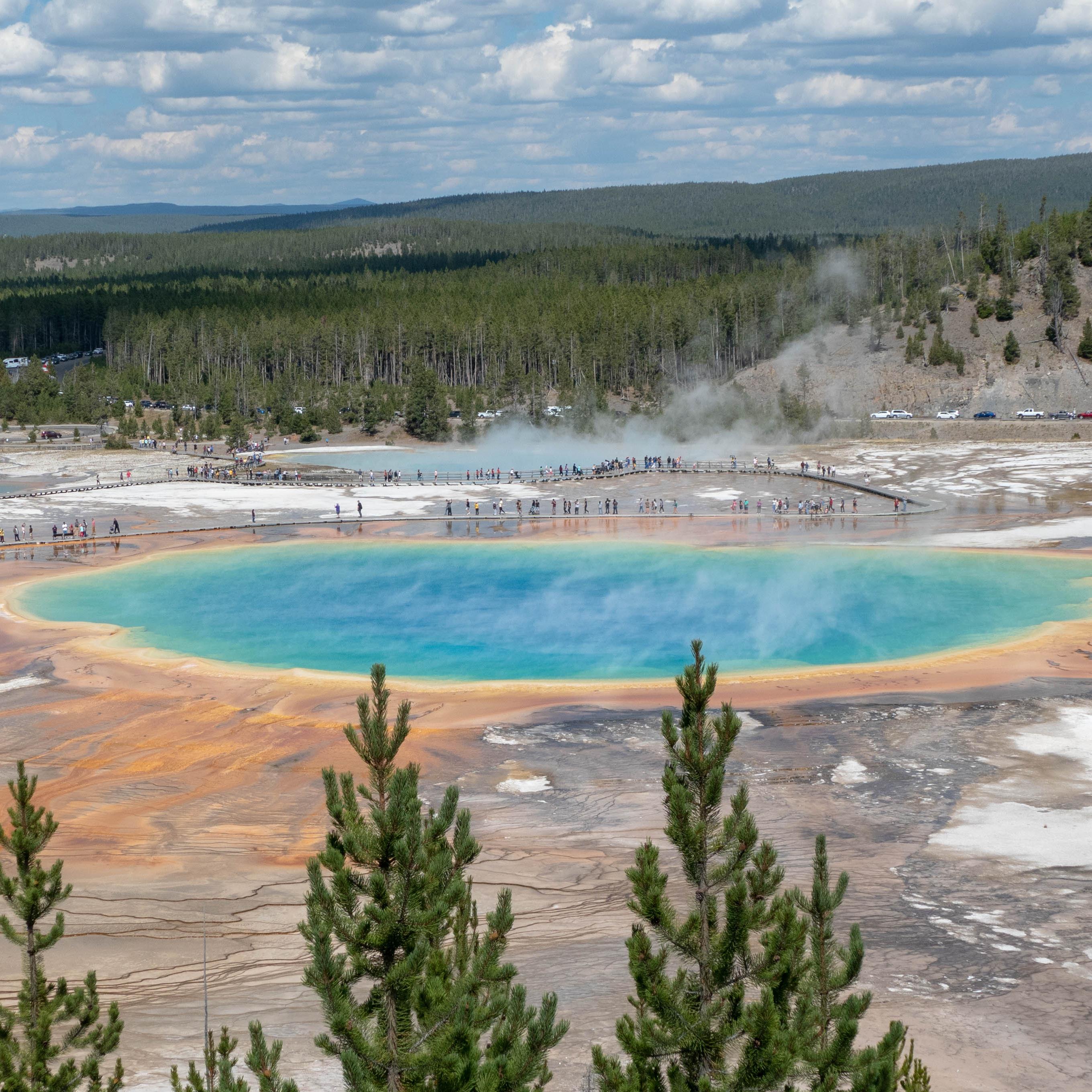 A large, colorful hot spring as viewed from above.