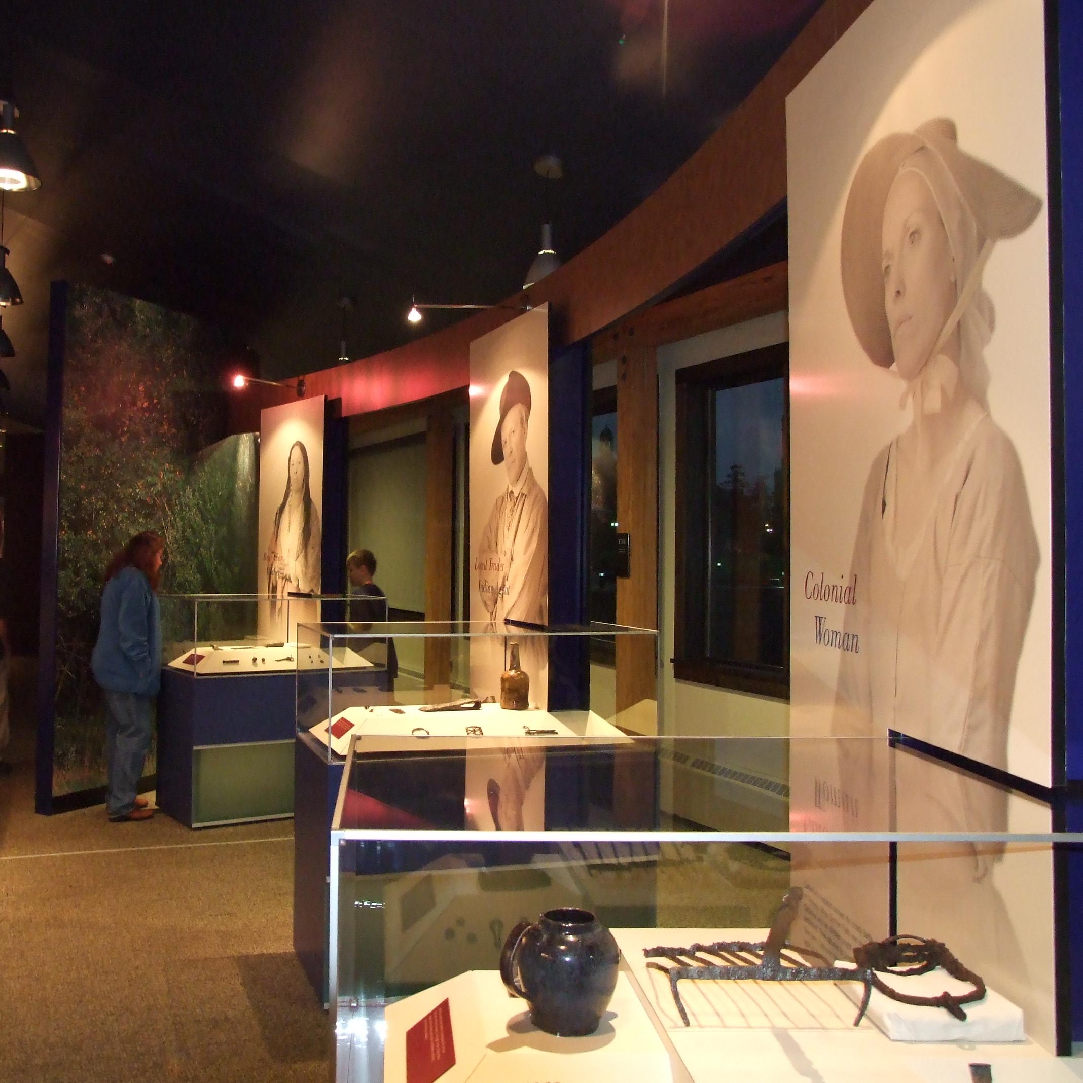 You can see three glass cases with artifacts inside and portraits next to them. 