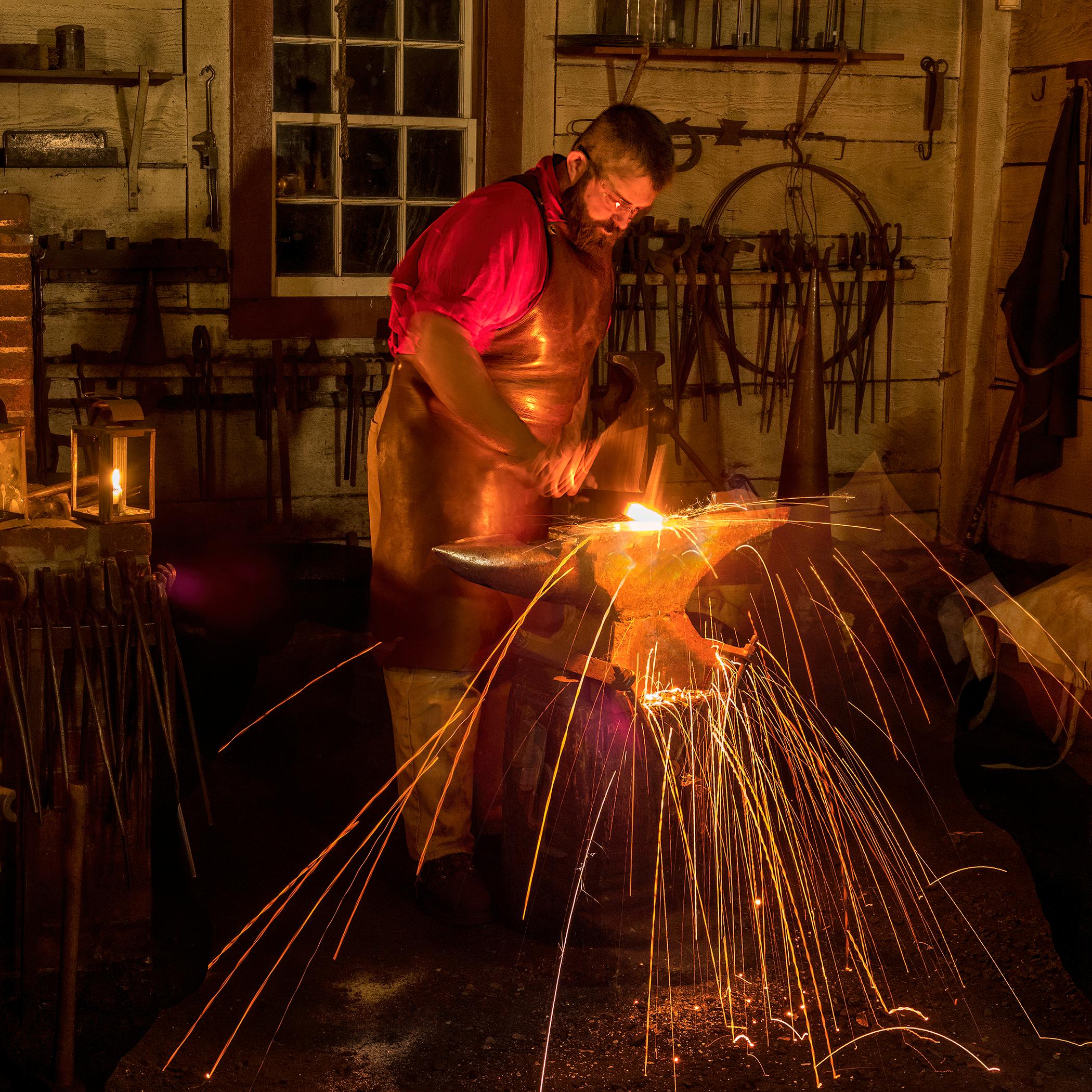 A blacksmith working inside the Blacksmith Shop at Fort Vancouver.