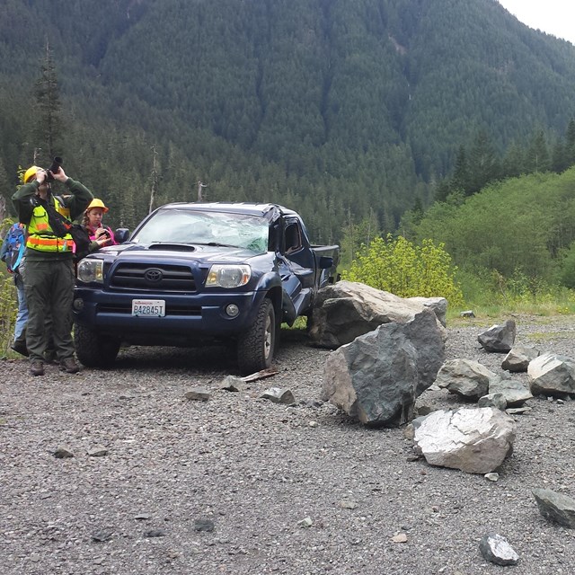 a vehicle damaged by rockfall on backcountry road
