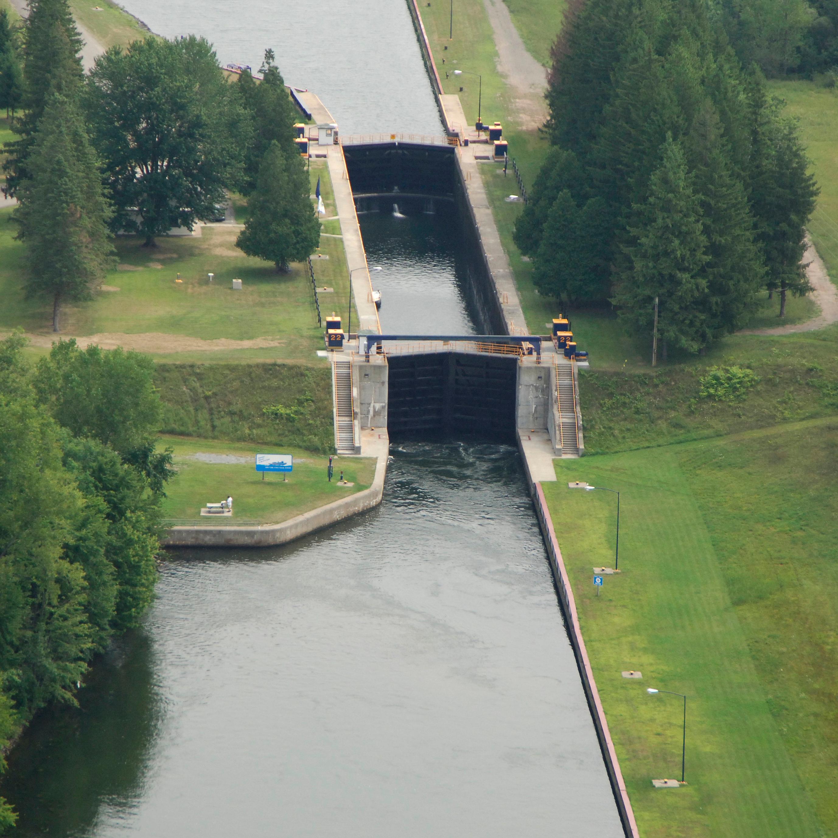 A view from above of a lock; large metal doors that block the water in a canal. 