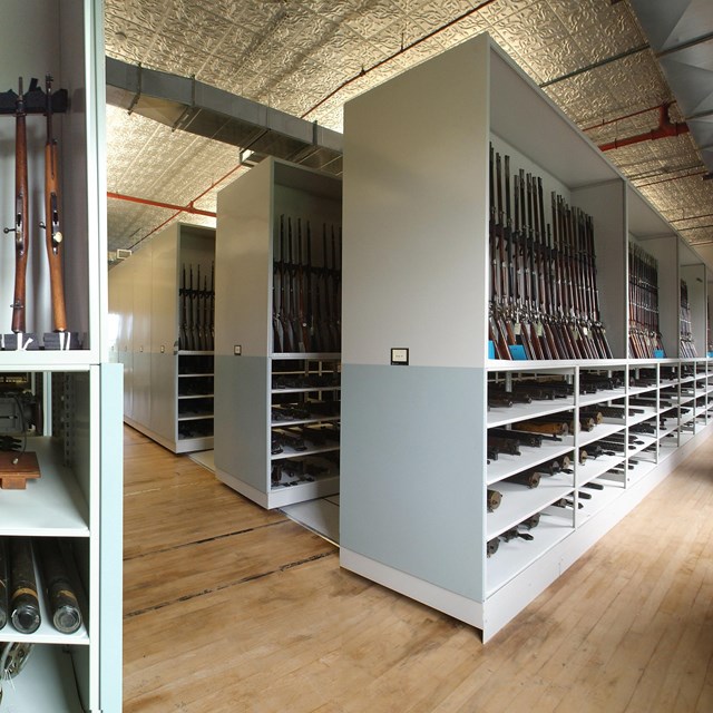 Giant white cabinets and shelves. In and on them there are rows of firearms, most with wooden stocks