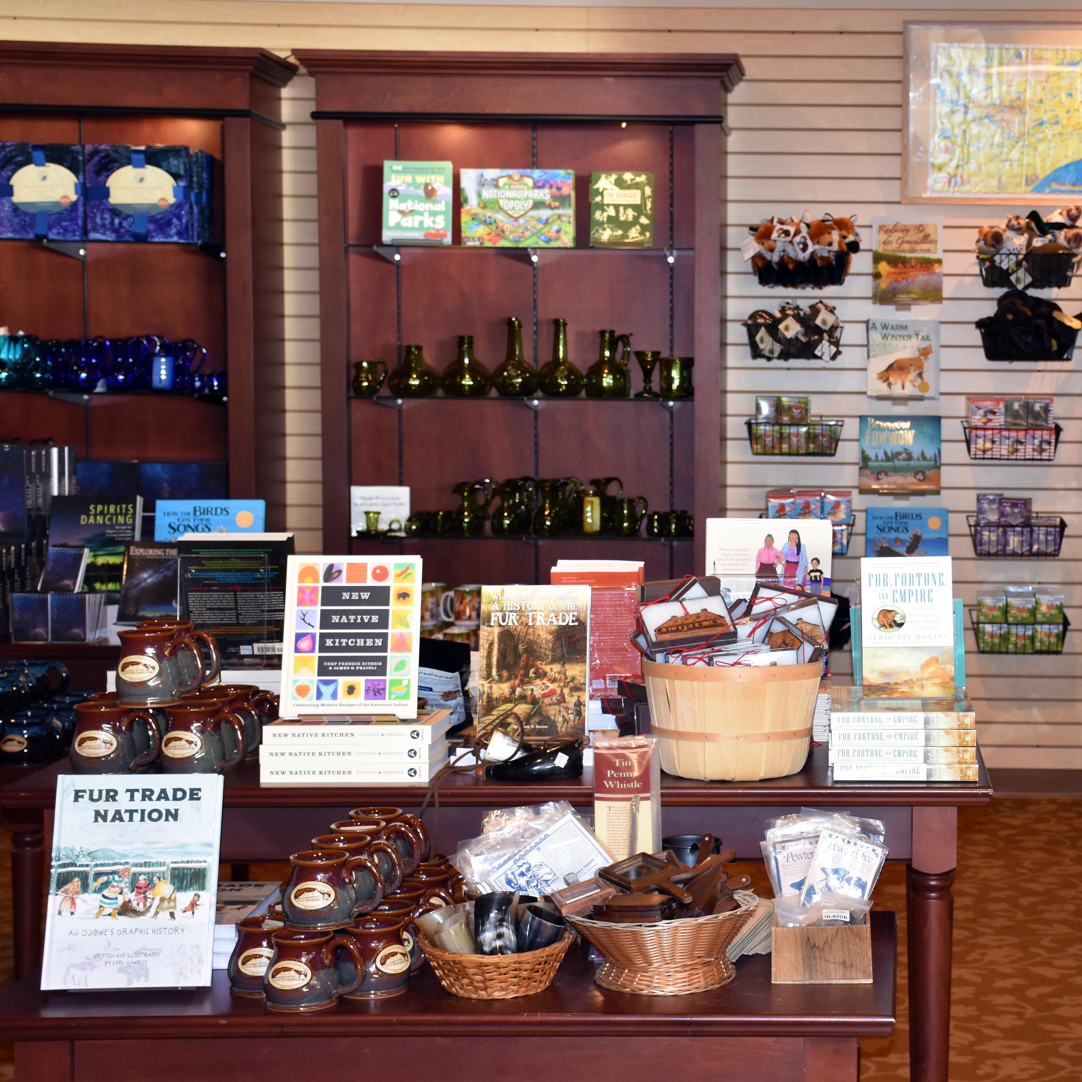 Books and other merchandise arrange on a tables and shelves.