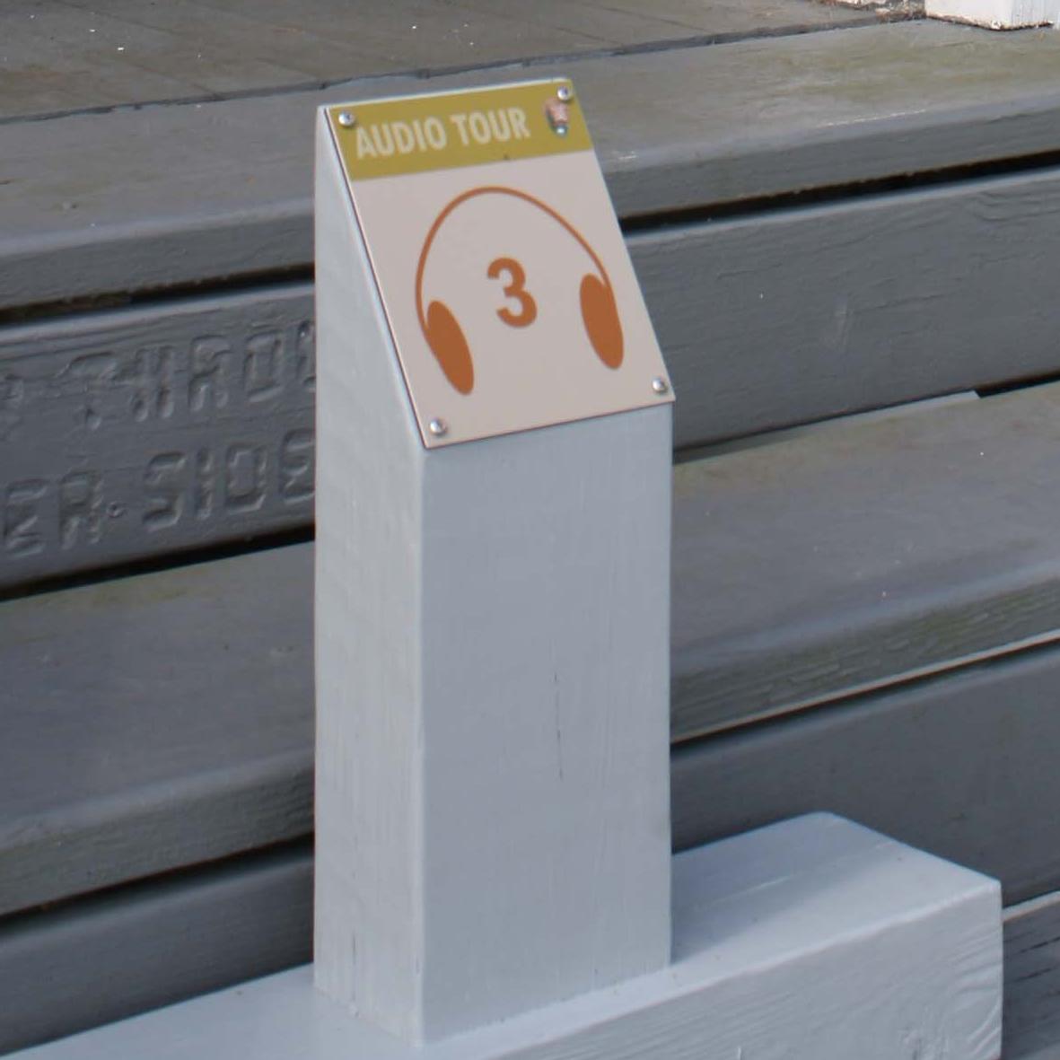 a sign on blue stairs reads 3 and has headphones