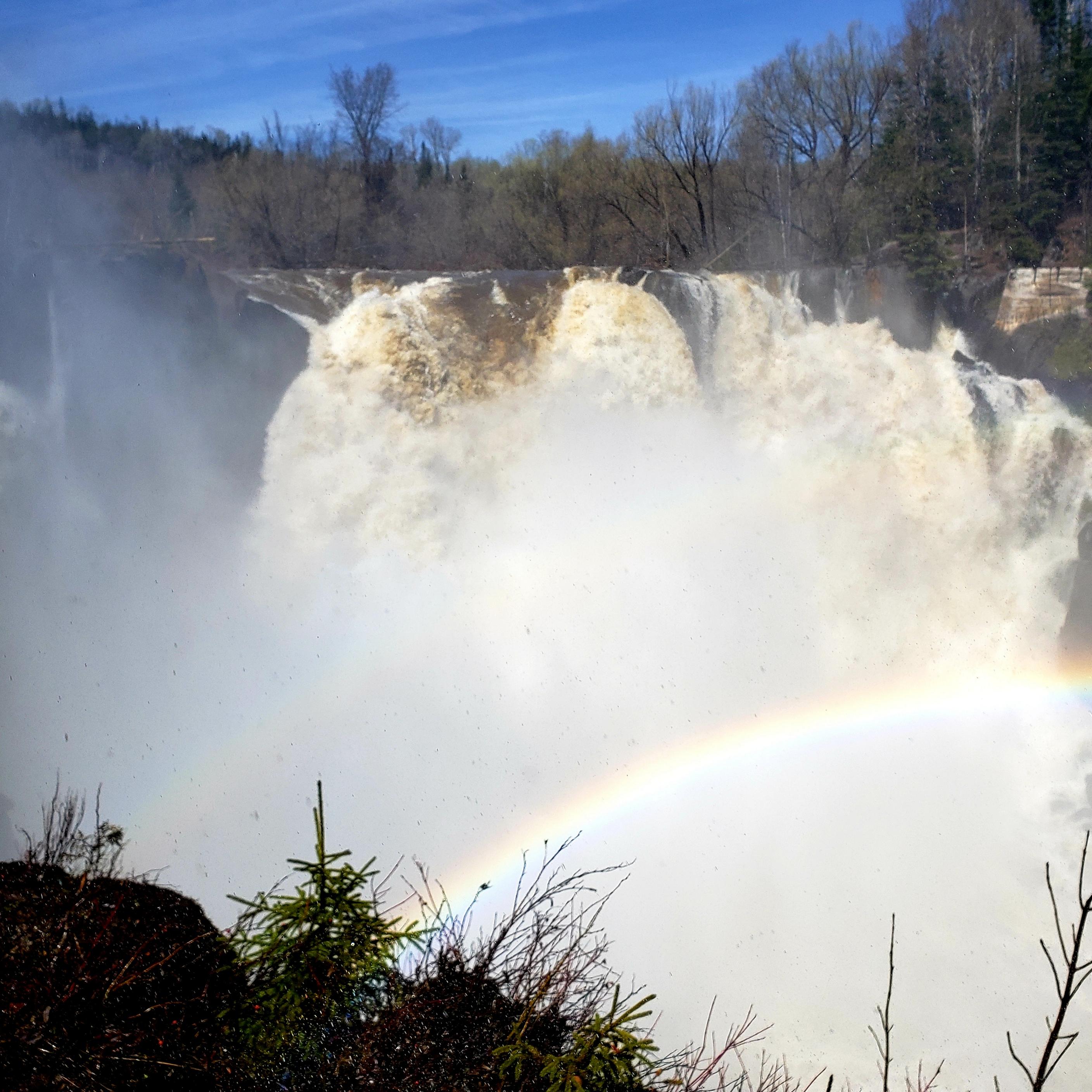 A waterfall with a rainbow in front