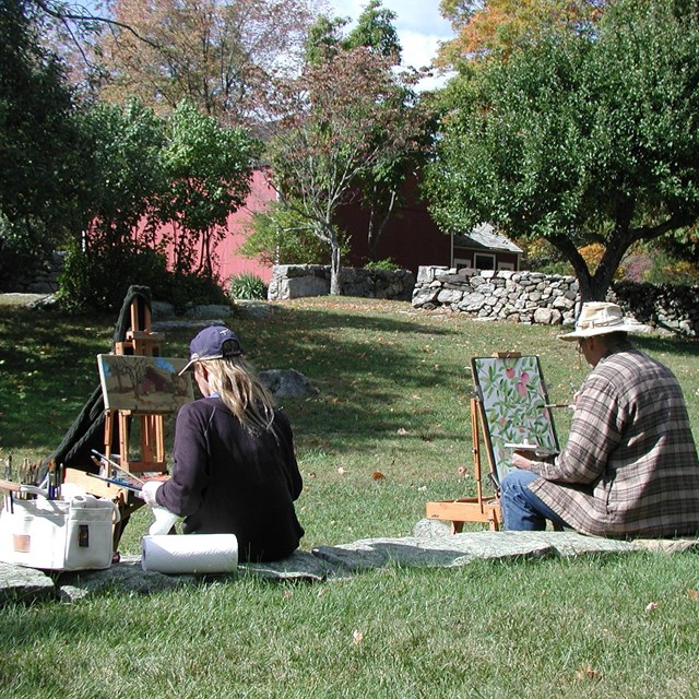 Two people painting on lawn