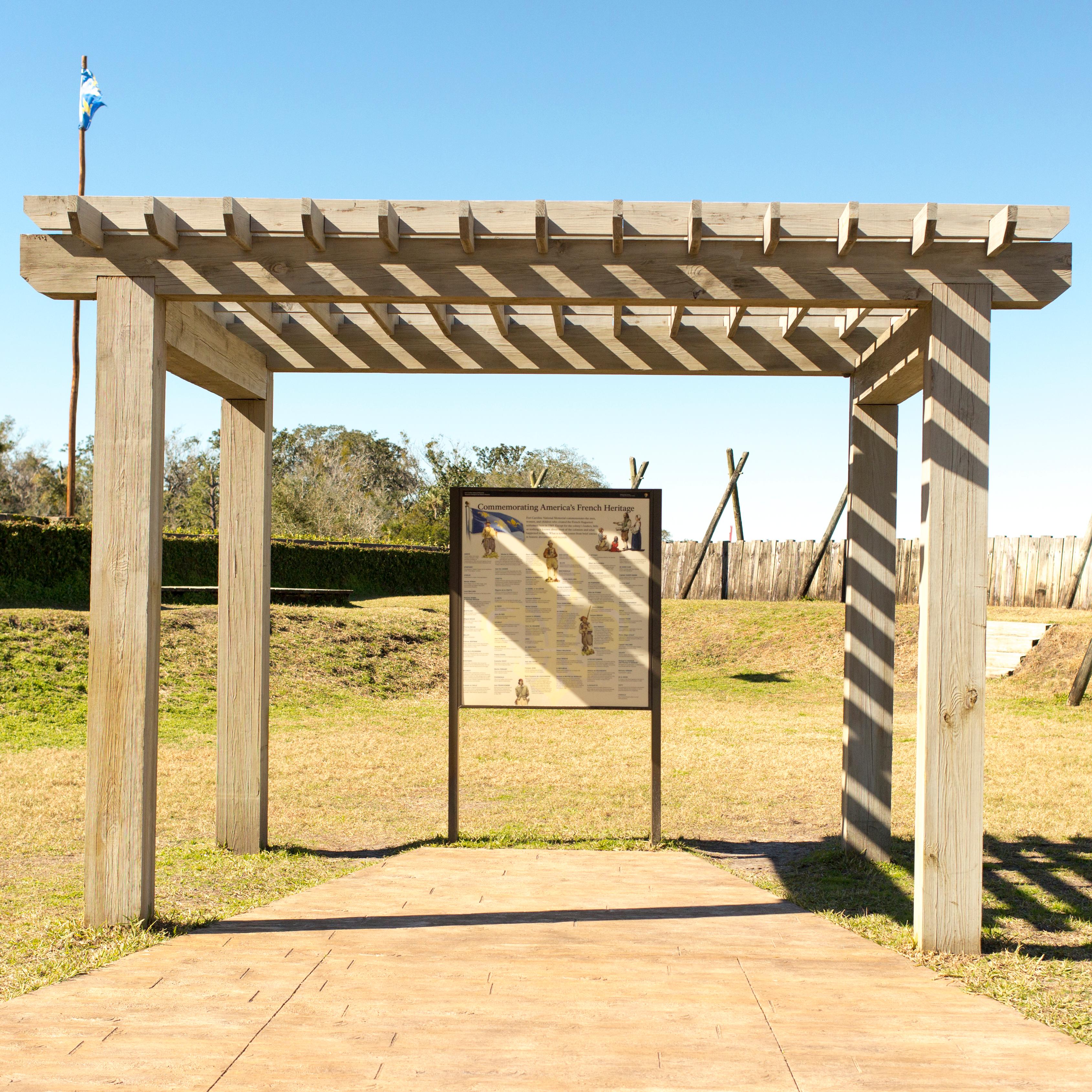 a pergola inside a fort with an exhibit panel listing names