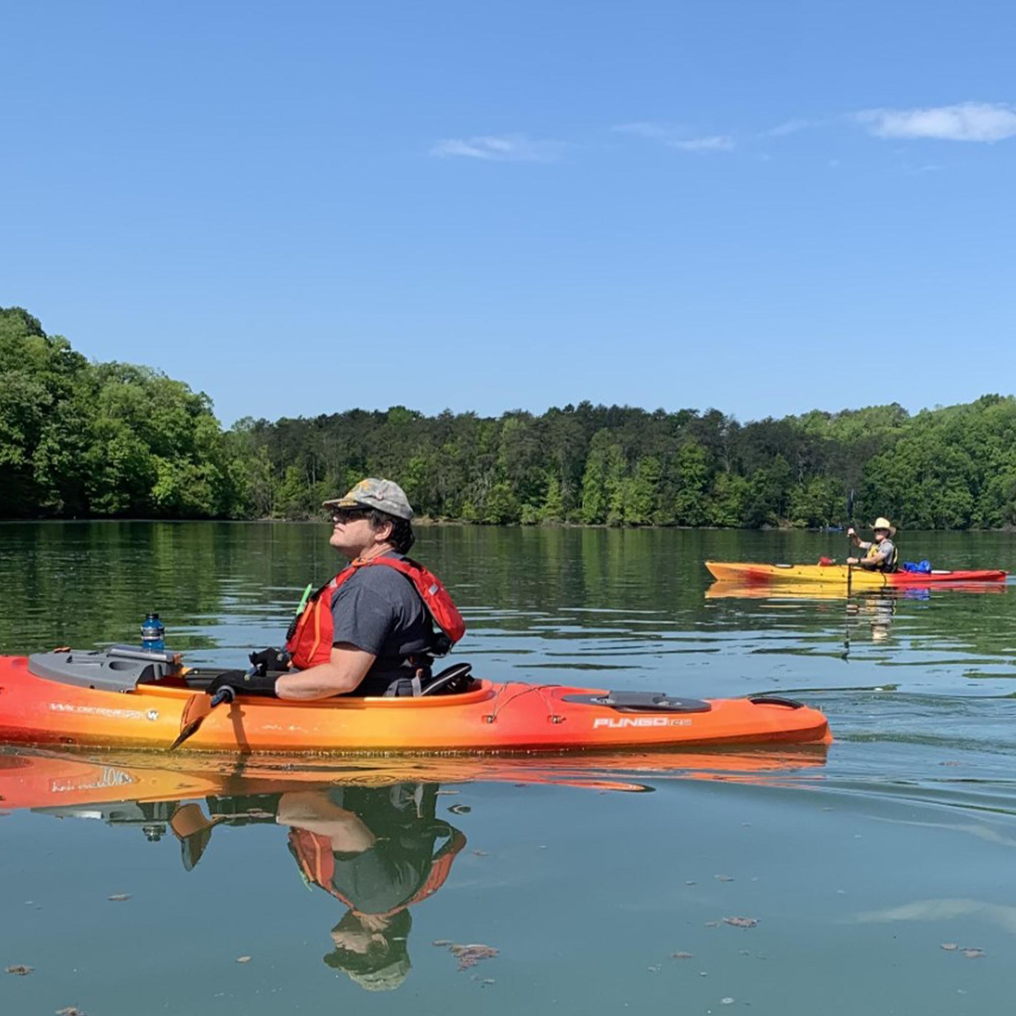 Two kayakers on the water on a sunny day.