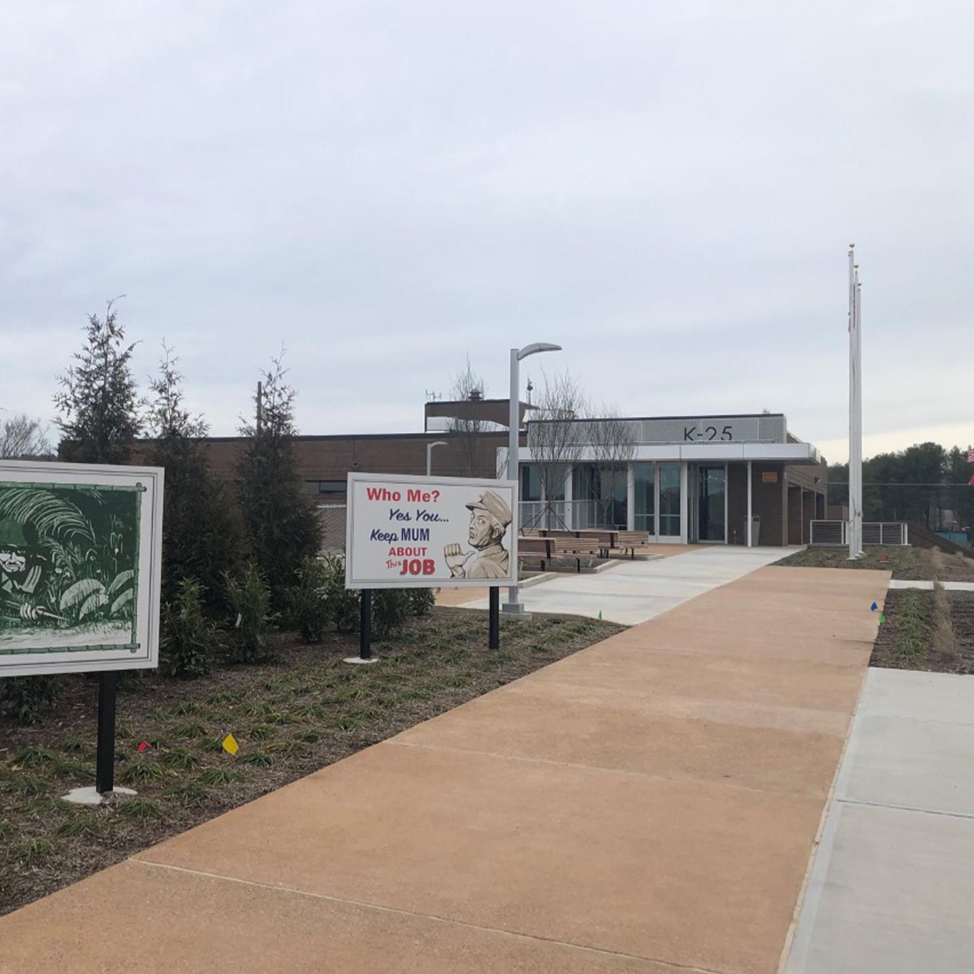 A small museum building with several retro billboards on the walkway in front of it.
