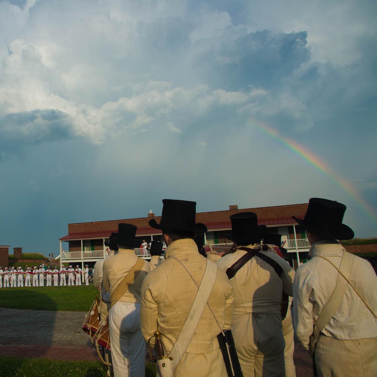 Living historians in the historic fort with a rainbow in the background.