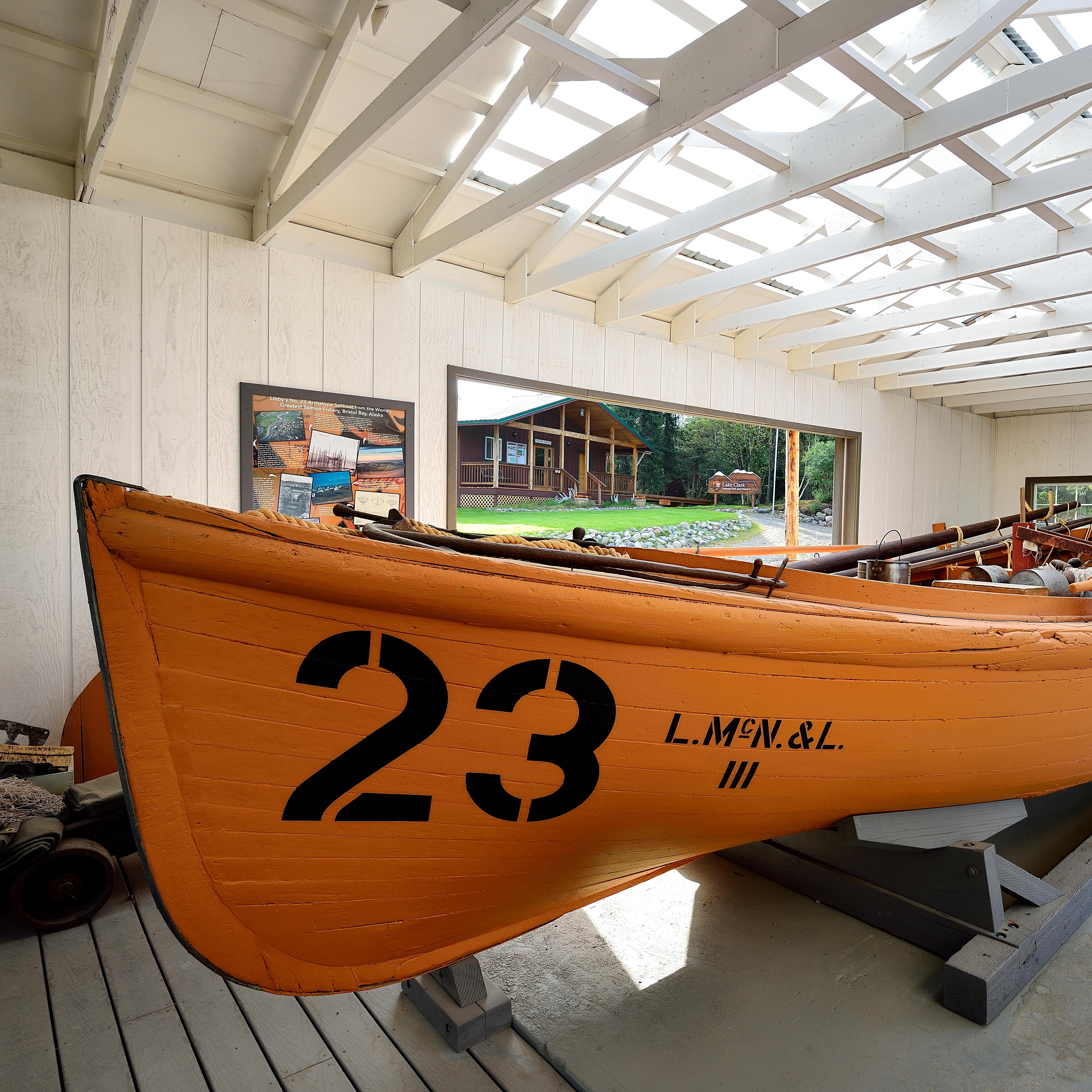 A large wooden boat sits with the number 23 painted on it.